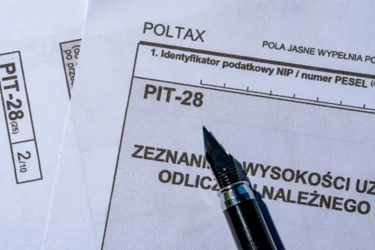 Zeznanie PIT-28, idealne do rozliczenia dochodów z najmu mieszkania. Pióro czeka na wpisanie kwot.